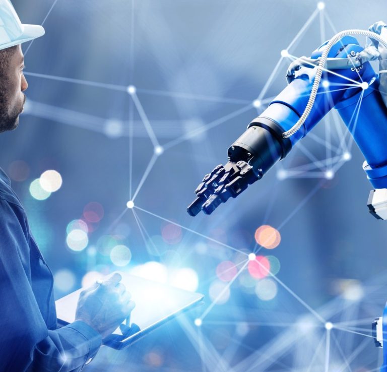 AI & Robotics A technician interacts with a robotic arm in a high-tech environment.